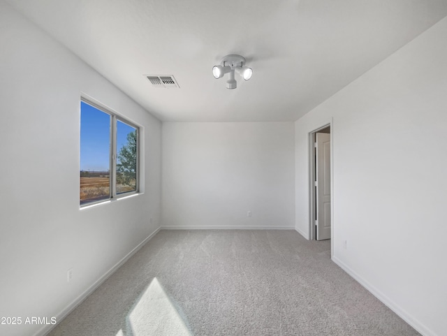 carpeted spare room with visible vents and baseboards