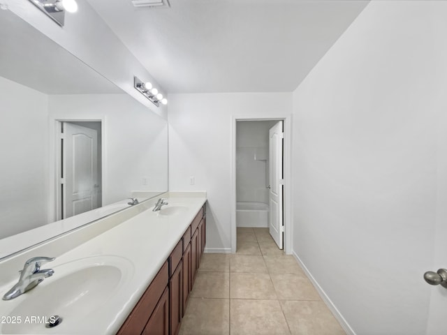 full bathroom with tile patterned flooring, double vanity, baseboards, and a sink