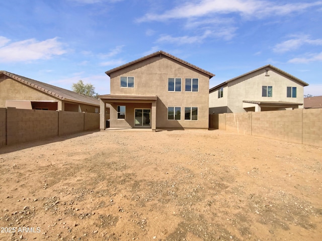 rear view of house with a patio area, a fenced backyard, and stucco siding