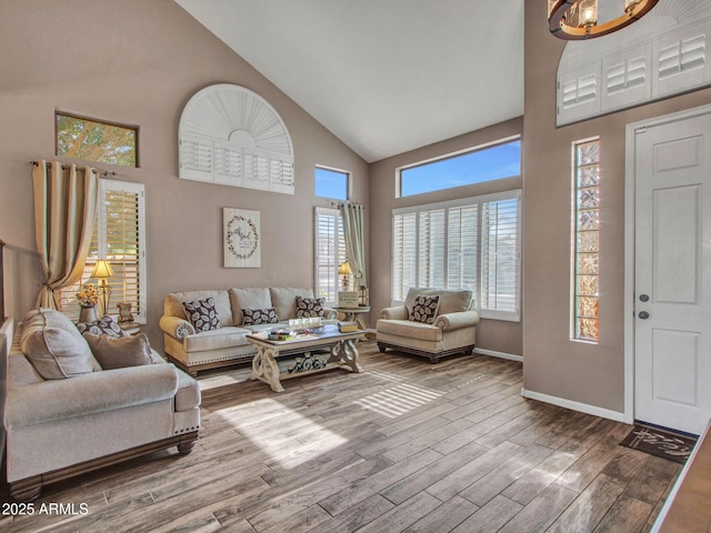 living room featuring hardwood / wood-style flooring, plenty of natural light, a chandelier, and high vaulted ceiling