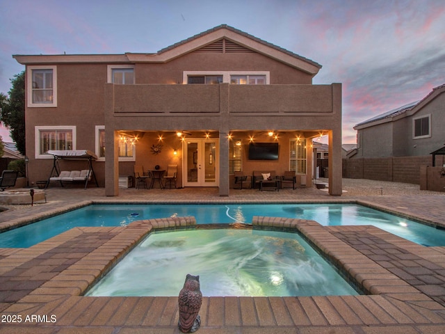 view of swimming pool featuring french doors, outdoor lounge area, a patio, and an in ground hot tub