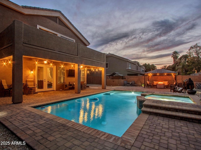 view of pool with an in ground hot tub, a patio area, a gazebo, and french doors