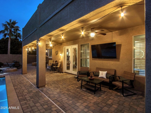 view of patio featuring an outdoor living space, ceiling fan, and french doors