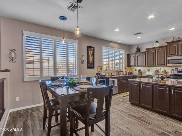 dining area featuring sink and light wood-type flooring