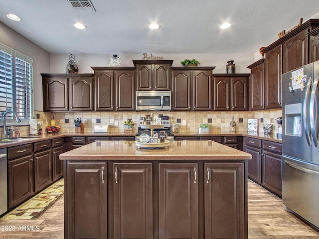 kitchen featuring sink, dark brown cabinets, and stainless steel appliances