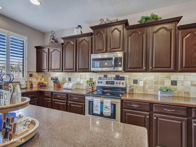 kitchen with tasteful backsplash, dark brown cabinets, and stainless steel appliances