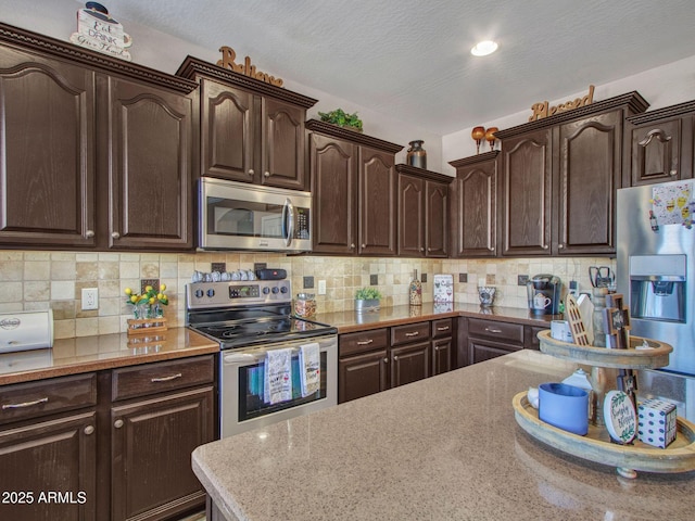 kitchen featuring dark brown cabinetry and appliances with stainless steel finishes