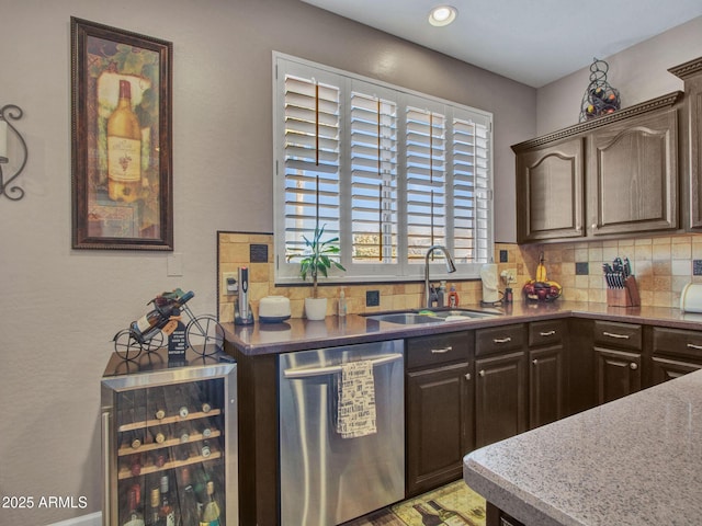 kitchen featuring stainless steel dishwasher, dark brown cabinetry, beverage cooler, and sink