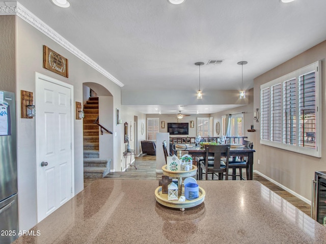 interior space with ornamental molding and ceiling fan