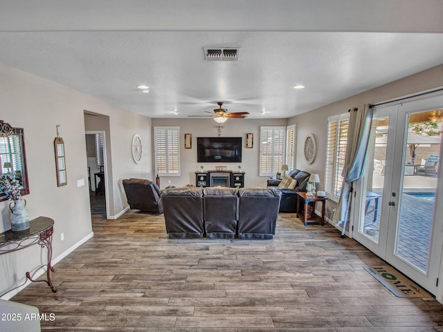 living room featuring french doors, ceiling fan, and wood-type flooring