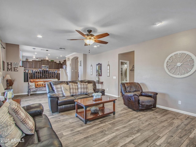 living room with light hardwood / wood-style flooring and ceiling fan