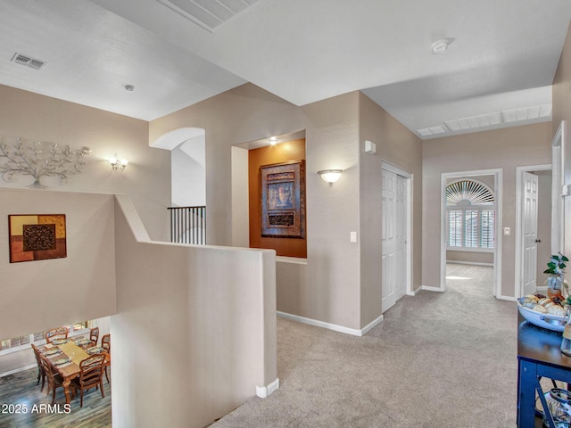 hall with light colored carpet