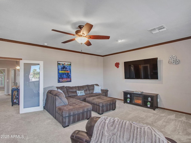 carpeted living room featuring ornamental molding and ceiling fan