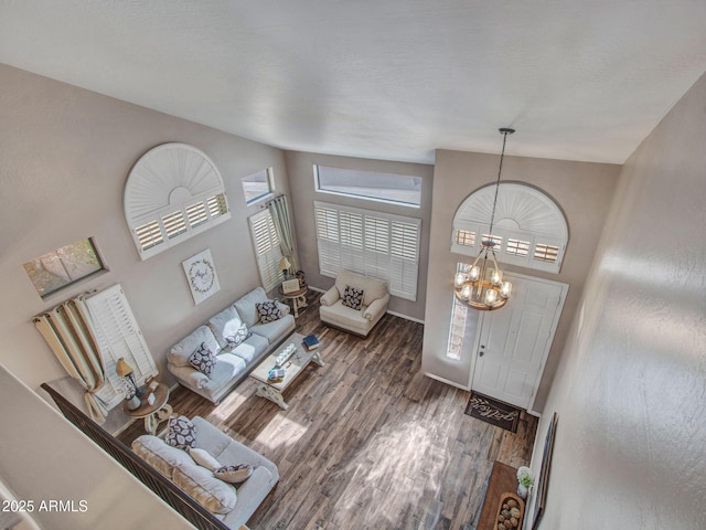 foyer entrance featuring an inviting chandelier, vaulted ceiling, and dark hardwood / wood-style floors