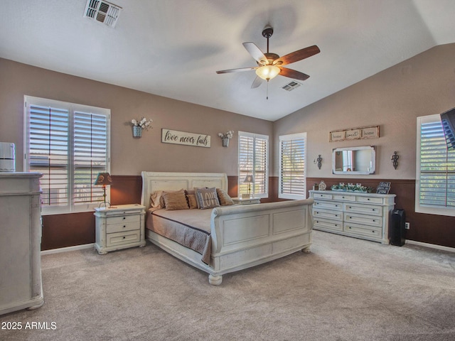 bedroom with multiple windows, light carpet, lofted ceiling, and ceiling fan