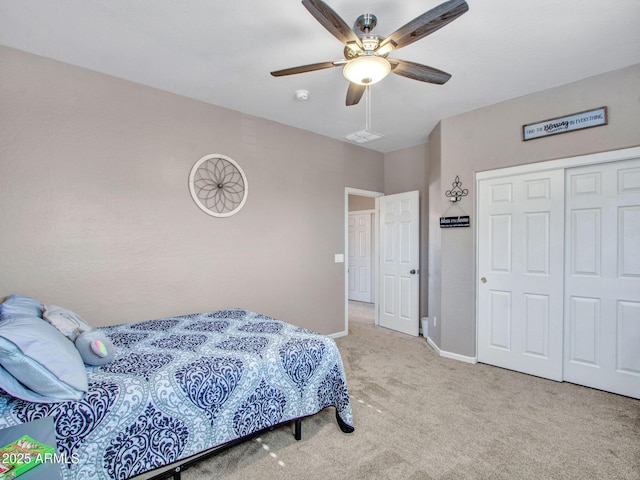 carpeted bedroom featuring ceiling fan and a closet