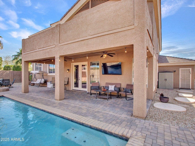 view of swimming pool with french doors, ceiling fan, and a patio