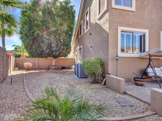 view of yard featuring central AC, a patio area, and an outdoor fire pit