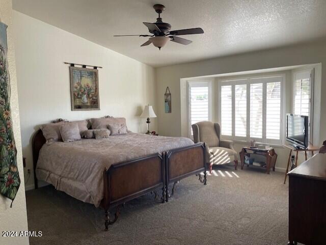 carpeted bedroom featuring ceiling fan, a textured ceiling, and vaulted ceiling