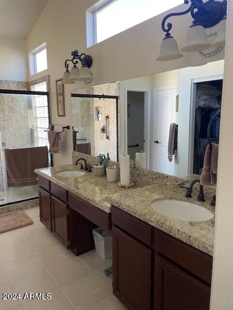 bathroom with vanity, high vaulted ceiling, tile patterned floors, and walk in shower