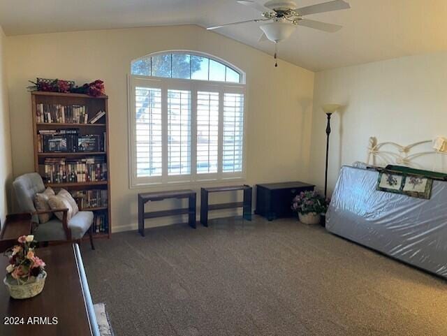 interior space featuring dark colored carpet, ceiling fan, and vaulted ceiling