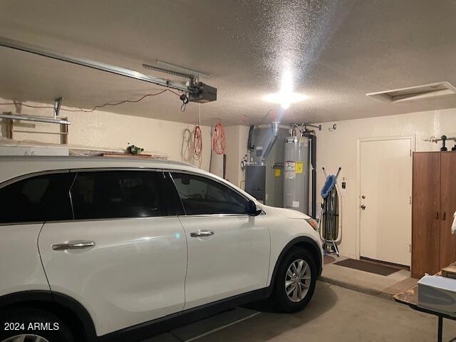 garage featuring heating unit, a garage door opener, and water heater