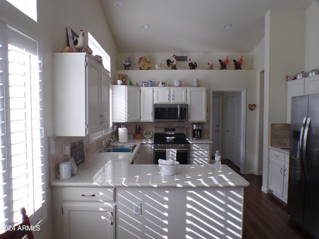 kitchen featuring kitchen peninsula, dark hardwood / wood-style floors, decorative backsplash, white cabinetry, and stainless steel appliances