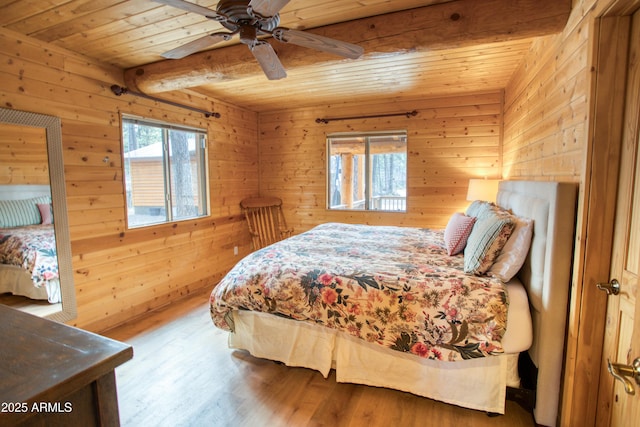 bedroom with wood ceiling, wood walls, beam ceiling, and hardwood / wood-style flooring