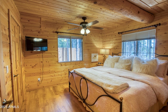 bedroom with multiple windows, wood ceiling, beam ceiling, and light wood-type flooring