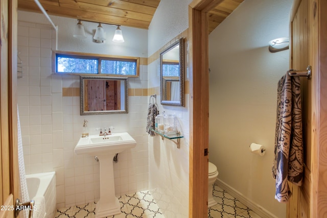 bathroom featuring tile walls, tile patterned flooring, shower / washtub combination, and toilet