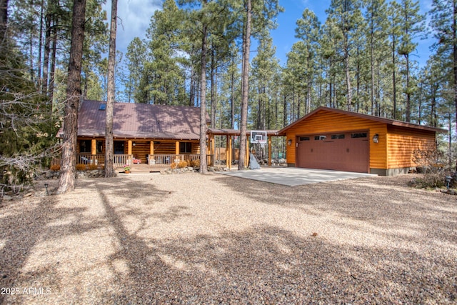 view of front of house featuring a garage, an outdoor structure, and covered porch