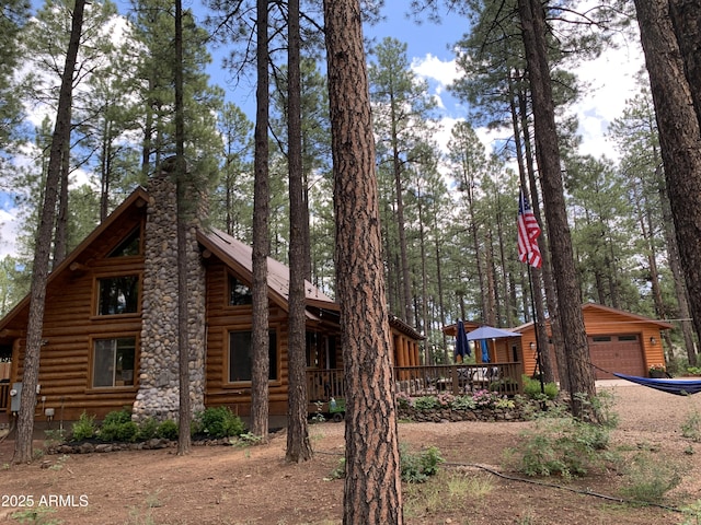 view of home's exterior featuring an outbuilding, a wooden deck, and a garage