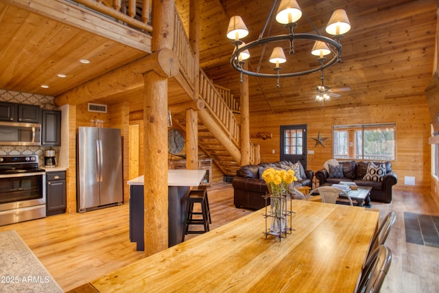 dining room with wood ceiling, high vaulted ceiling, and light wood-type flooring