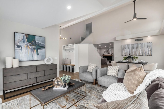 living room featuring hardwood / wood-style floors, a notable chandelier, and high vaulted ceiling