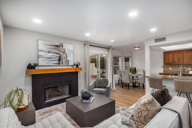 living room featuring sink and light hardwood / wood-style flooring