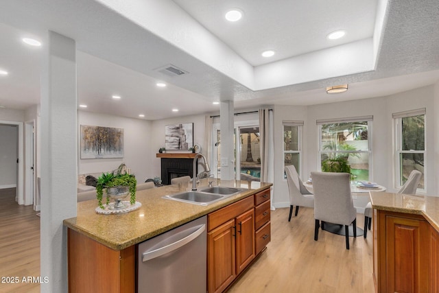 kitchen featuring sink, a tray ceiling, light hardwood / wood-style flooring, and dishwasher