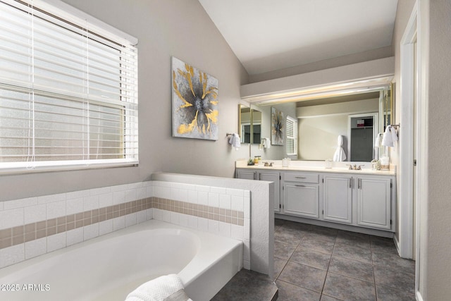 bathroom with vanity, tile patterned flooring, a bathtub, and lofted ceiling