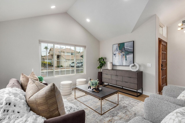 living room with high vaulted ceiling and light hardwood / wood-style flooring