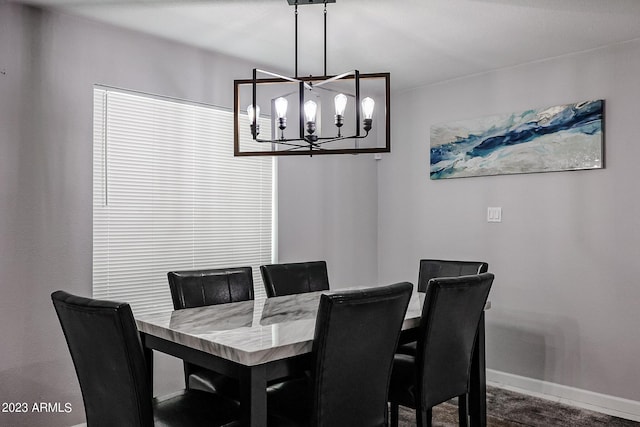 dining area featuring baseboards and an inviting chandelier