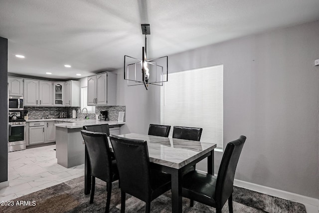 dining room with baseboards, marble finish floor, an inviting chandelier, and recessed lighting