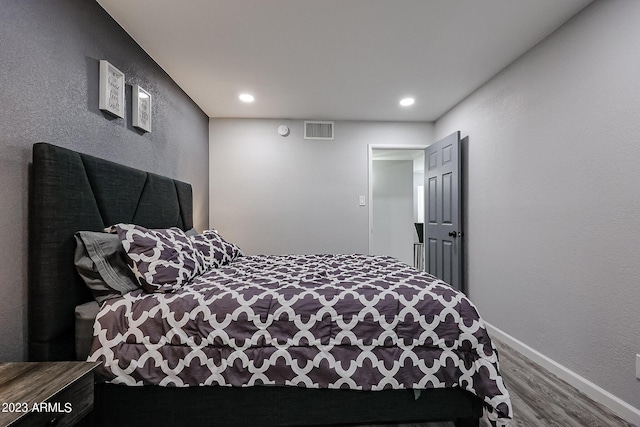 bedroom with recessed lighting, wood finished floors, visible vents, and baseboards