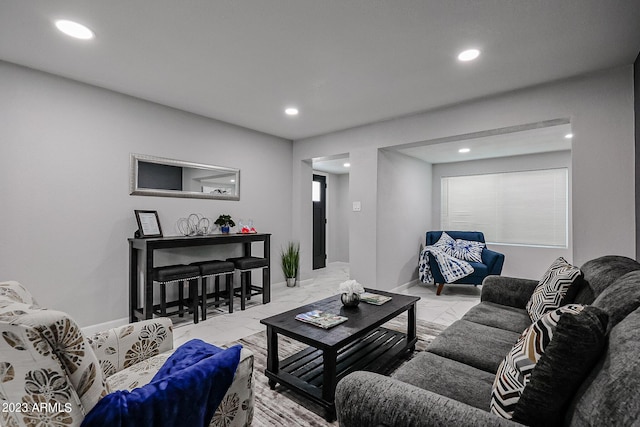 living area with baseboards, marble finish floor, and recessed lighting