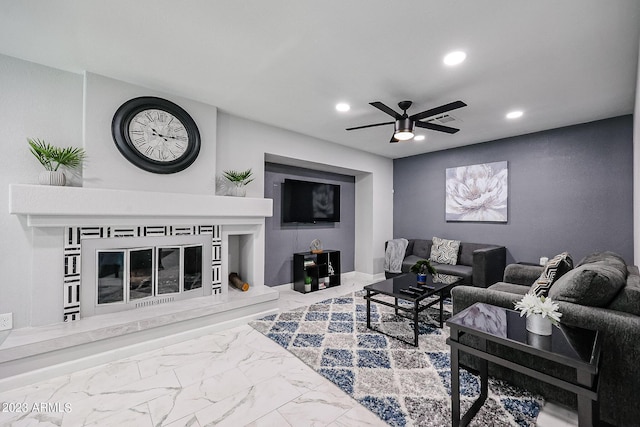 living room featuring visible vents, a glass covered fireplace, recessed lighting, marble finish floor, and ceiling fan