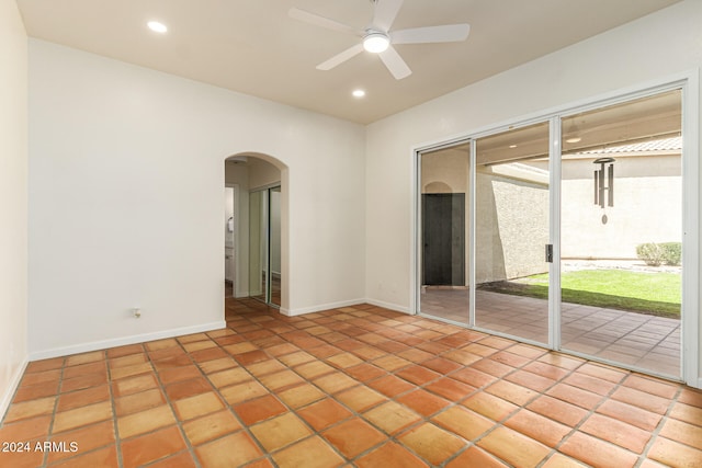 empty room with ceiling fan and light tile patterned floors