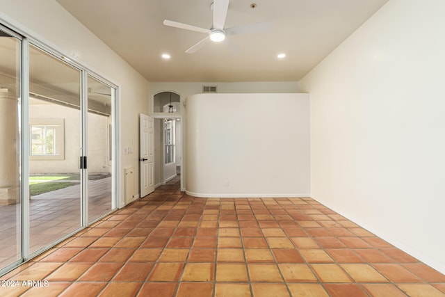 tiled empty room featuring ceiling fan