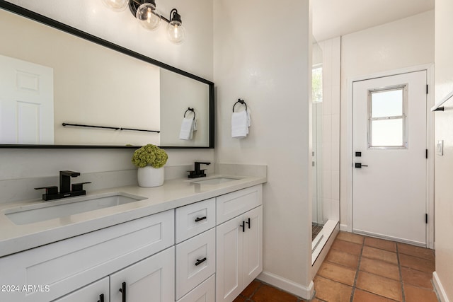 bathroom featuring an enclosed shower, dual bowl vanity, and tile patterned floors