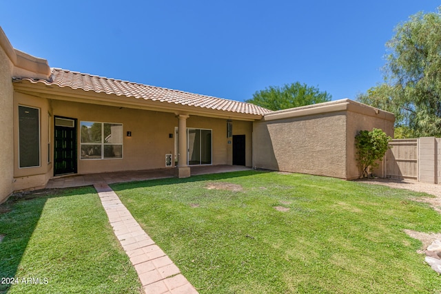 back of property with a patio and a yard