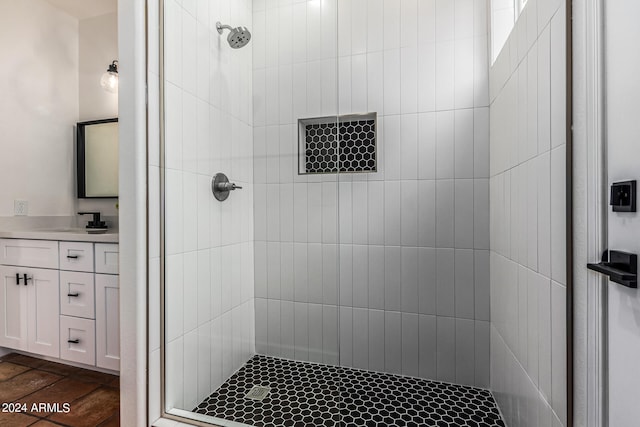 bathroom with tiled shower, vanity, and tile patterned floors