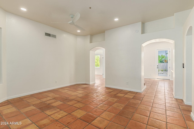 empty room with ceiling fan and tile patterned flooring