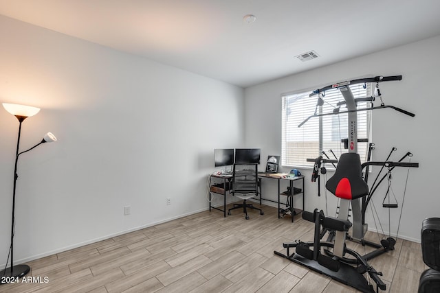 workout room with light hardwood / wood-style floors